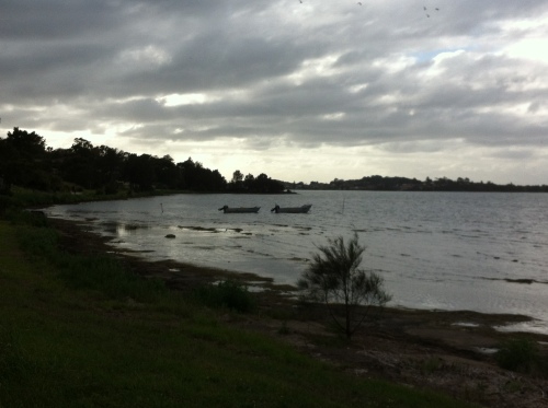 Storm clouds gathering over lLake Illawarra. Two boats boggong on the calm water